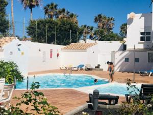 a woman standing in a swimming pool next to a house at Olas de Lobos in Corralejo