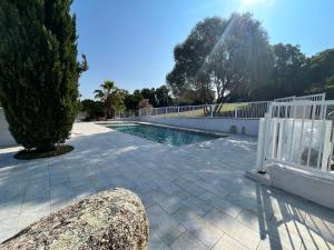 una piscina en un patio con una valla blanca en residence Catalani en Zonza