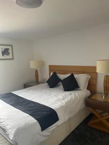 a bedroom with a large bed with two tables and two lamps at City apartments college street in Hull