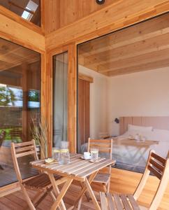 Habitación de madera con mesa, sillas y cama en Jókai7, en Mindszentkálla