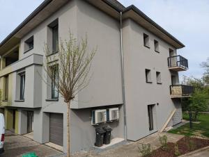 a white building with a tree in front of it at Renovated 2 Bedroom Apartment with Parking & AC in Luxembourg