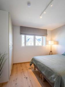 a white bedroom with a bed and a window at Renovated 2 Bedroom Apartment with Parking & AC in Luxembourg