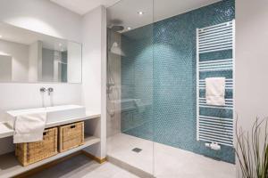 a bathroom with a sink and a glass shower at Renovated 2 Bedroom Apartment with Parking & AC in Luxembourg