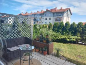 balkon z kanapą i stołem oraz budynek w obiekcie Apartament Żeglarska Gdańsk- Borkowo w mieście Borkowo