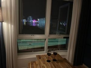 two glasses of wine sitting on a table in front of a window at Sokcho Marinabay 305 "Lake View" in Sokcho
