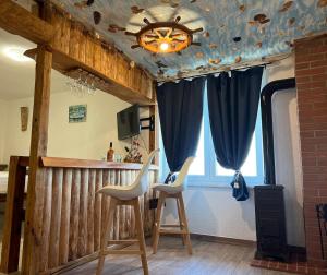 Zimmer mit 2 Stühlen und einer Bar mit blauen Vorhängen in der Unterkunft ViSTAMaRE Apartment in Opatija