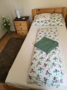 2 aparte bedden in een slaapkamer met bloemen erop bij Zsuzsa Vendégháza in Balatonfüred