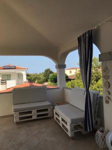 a balcony with a couch and a view of a house at Via Genova 1480 in San Teodoro