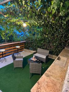 eine Terrasse mit Stühlen, einem Tisch und einer Hecke in der Unterkunft ViSTAMaRE Apartment in Opatija