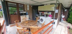 a kitchen and dining room with a table and chairs at Kamp prikolica četvorokrevetna in Crnča