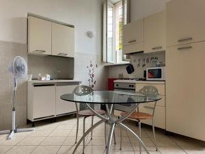 eine Küche mit einem Glastisch und 2 Stühlen in der Unterkunft Minimal Loft in centro a Piacenza in Piacenza