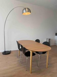 una mesa de madera con sillas negras y una lámpara en New and modern apartment in the city center, en Maastricht