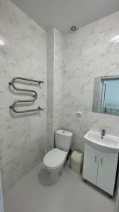 bagno bianco con servizi igienici e lavandino di Перлина Дністра a Rudkovtsy