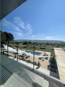 - une vue sur la piscine depuis le balcon d'une maison dans l'établissement Les pins du Luberon, à Coustellet