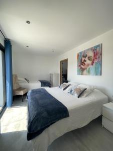 a bedroom with a large bed with a painting on the wall at Les pins du Luberon in Coustellet