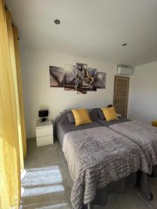 - une chambre avec un lit et des oreillers jaunes dans l'établissement Les pins du Luberon, à Coustellet