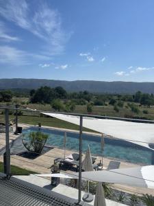 - une vue sur la piscine avec des parasols dans l'établissement Les pins du Luberon, à Coustellet