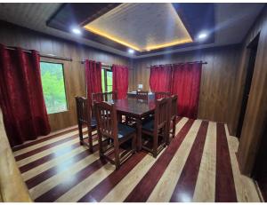 a dining room with a table and red curtains at Grand Mala Resorts, Pahalgam in Pahalgām