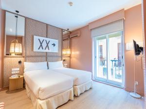 a bedroom with two beds and a large window at U-Sense Granada Centro in Granada