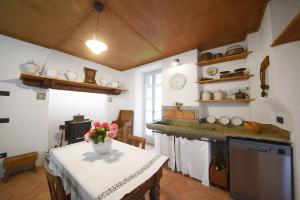 San BernardoにあるPiano nobile al Roseto del Dragoの花瓶に花が飾られたテーブルのあるキッチン