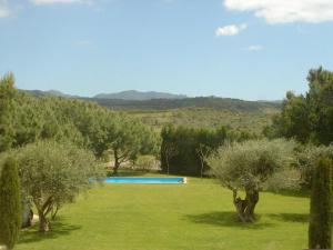 a pool in a field with trees and hills in the background at Hotel Canaleta Heras in Espolla