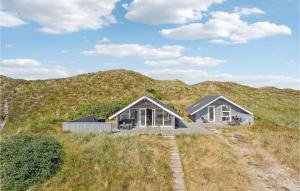two houses on top of a hill with grass at Amazing Home In Hvide Sande With Kitchen in Havrvig