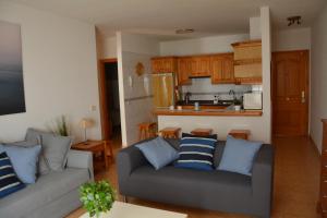 a living room with a couch and a kitchen at Apartamento Salitre in Puertito de Güímar