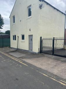 a white building with a fence next to a street at City apartments college street in Hull