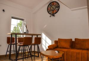 een woonkamer met een bank, een tafel en een klok bij Apartman Nada in Novi Vinodolski