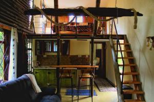 a loft bed in a room with a table and a ladder at The Murana Chalet in Nanyuki