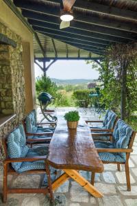 drewniany stół i krzesła na patio w obiekcie Country Cottage I & Country Cottage II w mieście Polijiros