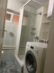 a washing machine in a bathroom with a shower at Apartman K&K in Pirot