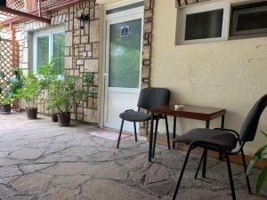 a patio with two chairs and a table and a door at Apartman K&K in Pirot