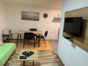 a living room with a table and chairs and a tv at Apartman K&K in Pirot