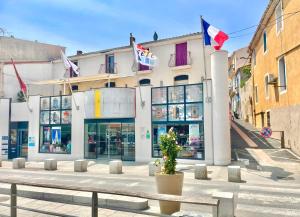 a store on a street with flags in front of it at Grand studio sur la Marine in Sète