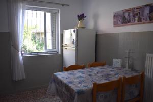 uma cozinha com uma mesa e um frigorífico branco em Tim's House em Kallikrateia