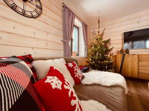 ein Wohnzimmer mit einem Weihnachtsbaum und einer Couch in der Unterkunft Mountain Houses Kubínska hoľa in Dolný Kubín