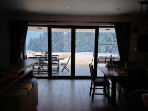 a dining room with a view of a deck with snow at Mountain Houses Kubínska hoľa in Dolný Kubín