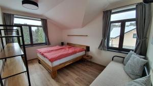 niewielka sypialnia z łóżkiem i 2 oknami w obiekcie Mountain Houses Kubínska hoľa w mieście Dolný Kubín