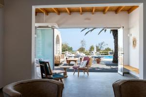 a patio with chairs and a table and a pool at Pnoi Hotel in Logaras