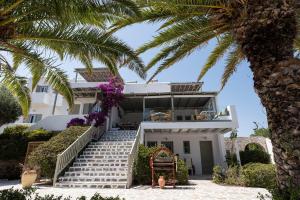 a house on the beach with a palm tree at Pnoi Hotel in Logaras