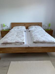 1 dormitorio con 1 cama de madera y 2 almohadas en Albblick en Albstadt