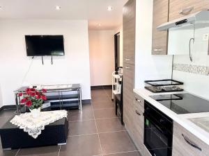 a kitchen with a table with flowers on it at Appartement élégant - 12min CDG in Dammartin-en-Goële