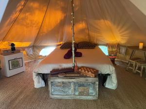 a bed in a tent with a table next to it at CYBÈLE in Bernac
