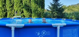 two people swimming in a swimming pool at Kamp prikolica četvorokrevetna in Crnča