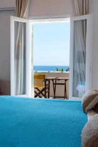 a bedroom with a bed with a view of the ocean at Pnoi Hotel in Logaras