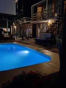 a blue swimming pool in front of a house at night at Posada Don Manuel in Paso de los Toros