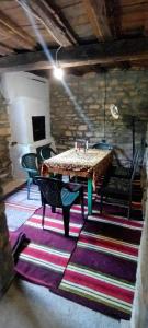ПРИ ШИВАЧА في Kŭrpachevo: غرفة مع طاولة وكراسي على سجادة ملونة