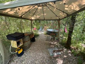 a tent with a table and a stove and a barrel at Ironvan in Bernac +4 photos