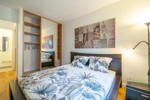 a bedroom with a bed with blue and white sheets at Havre de paix - Appt avec terrasse in Courbevoie